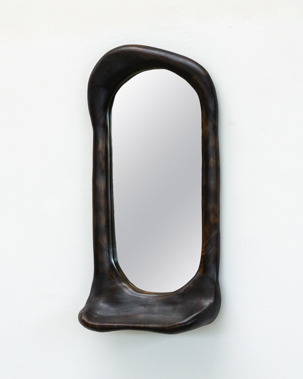 sculptural mirror with shelf in charred walnut