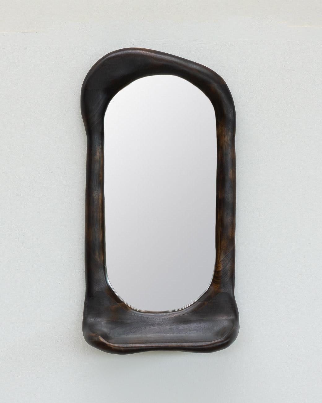 sculptural mirror with shelf in charred walnut